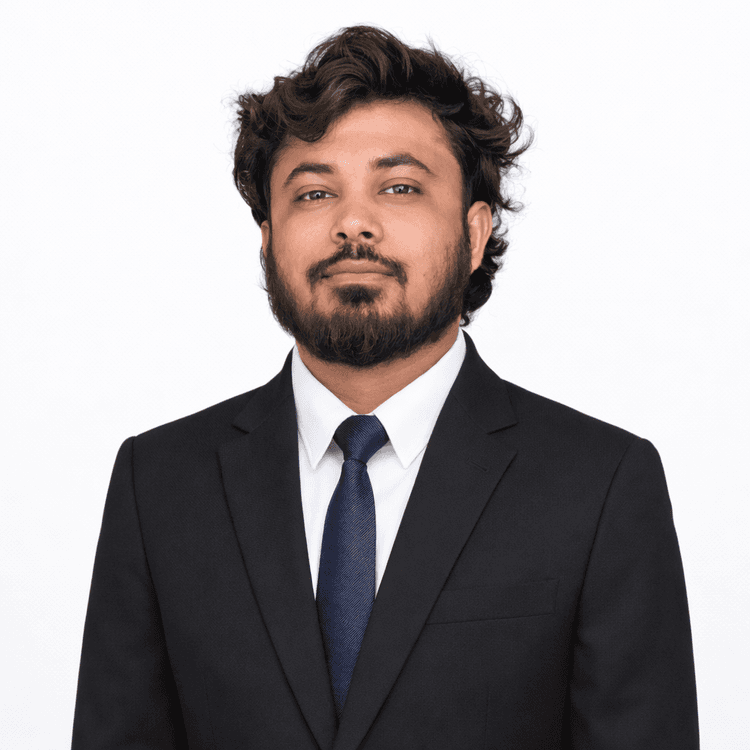 Young professional man in black suit and blue tie looking up thoughtfully on white background.